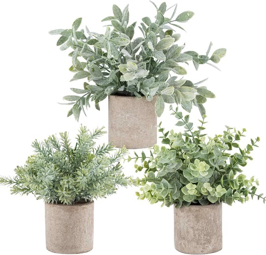 Three mini potted artificial eucalyptus plants in a stylish ceramic pot.