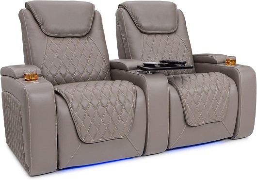 A couple is comfortably relaxing in reclining Seatcraft Muse theater seats with powered headrests and lumbar support.