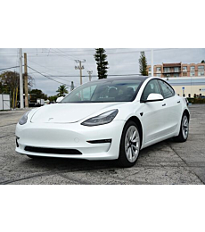 2023 Tesla Model 3 cruising on a scenic road, highlighting sleek design and performance