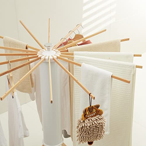Foldable Tripod Clothes Drying Rack with clothes hanging on it indoors.