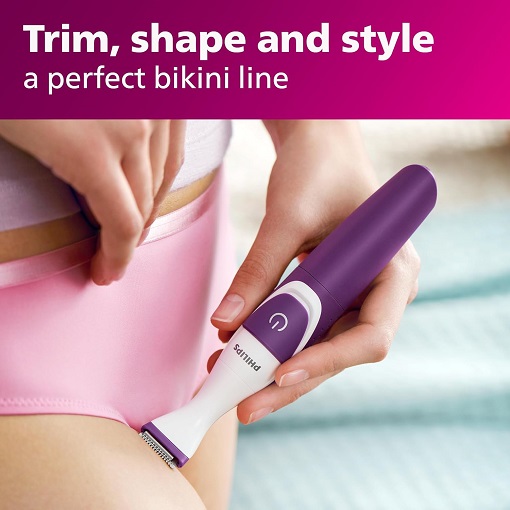 Woman using Philips Bikini Genie trimmer on bikini line, smooth results.