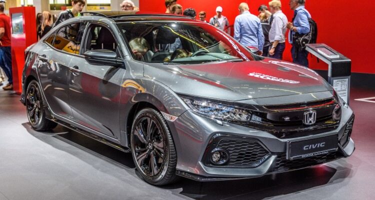 A sleek Honda Civic displayed at a car exhibition, surrounded by visitors