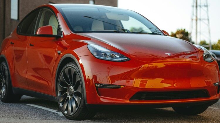  red Tesla Model 3 electric car parked in a parking lot