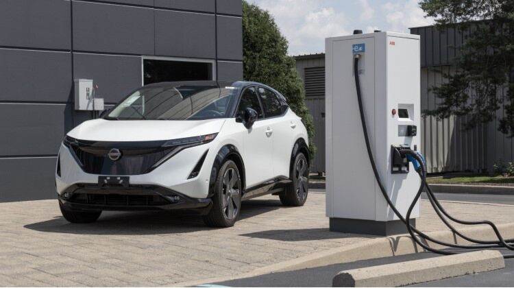 White Nissan Ariya plugged into a charging station